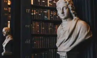 man wearing robe bust figurine near black wall