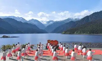a group of people in white karate uniforms on a dock by a lake